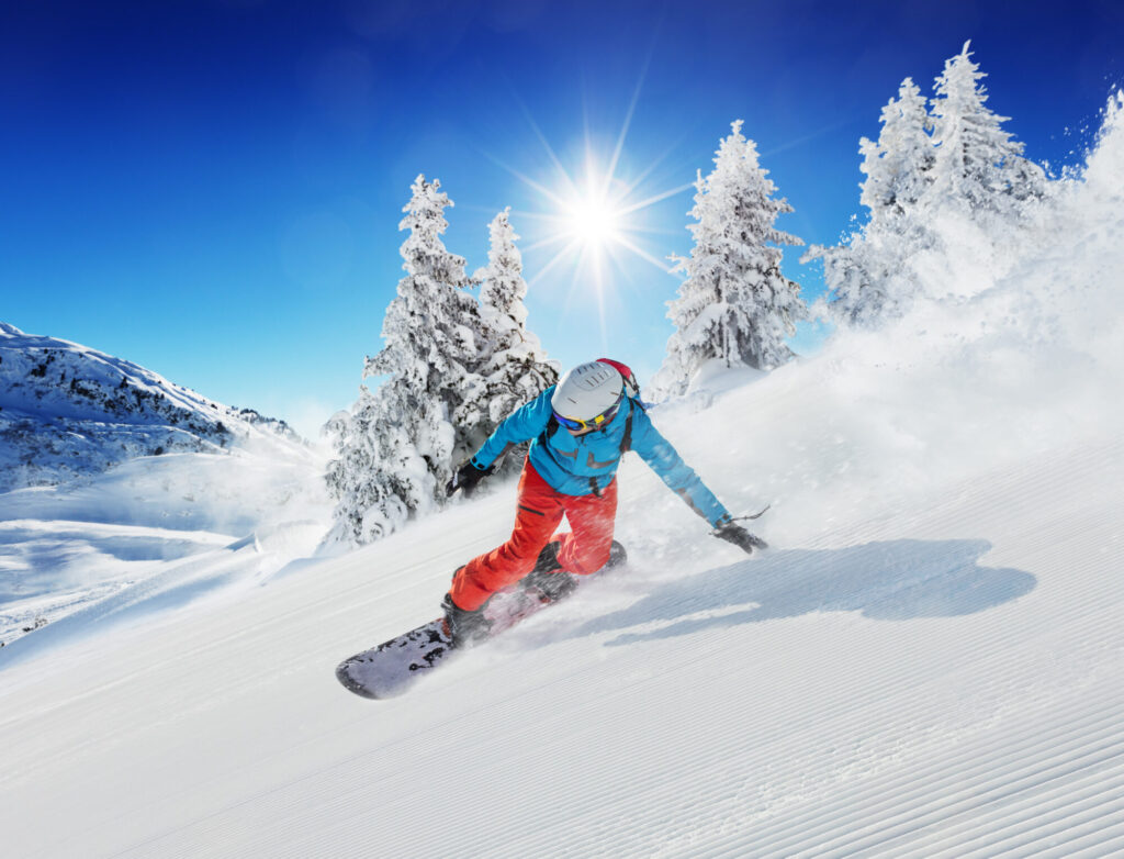 snowboarder qui descend une pente enneigée