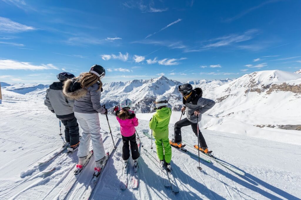 famille de skieur en haut d'un massif enneigé